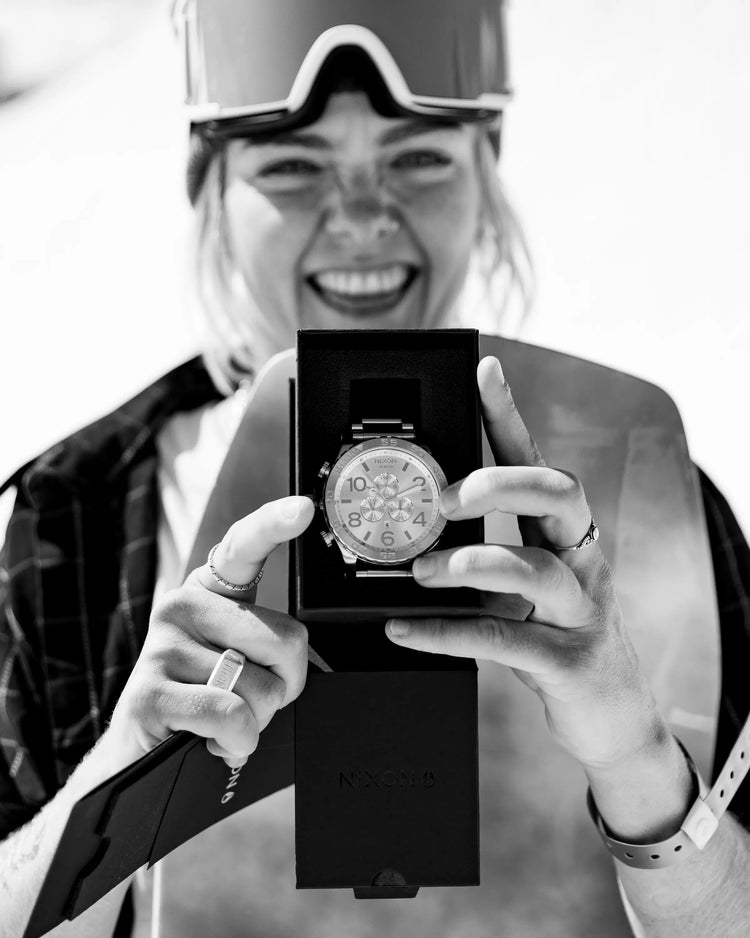 A female snowboarder poses with her Nixon Best Time Award 51-30 Chrono trophy watch