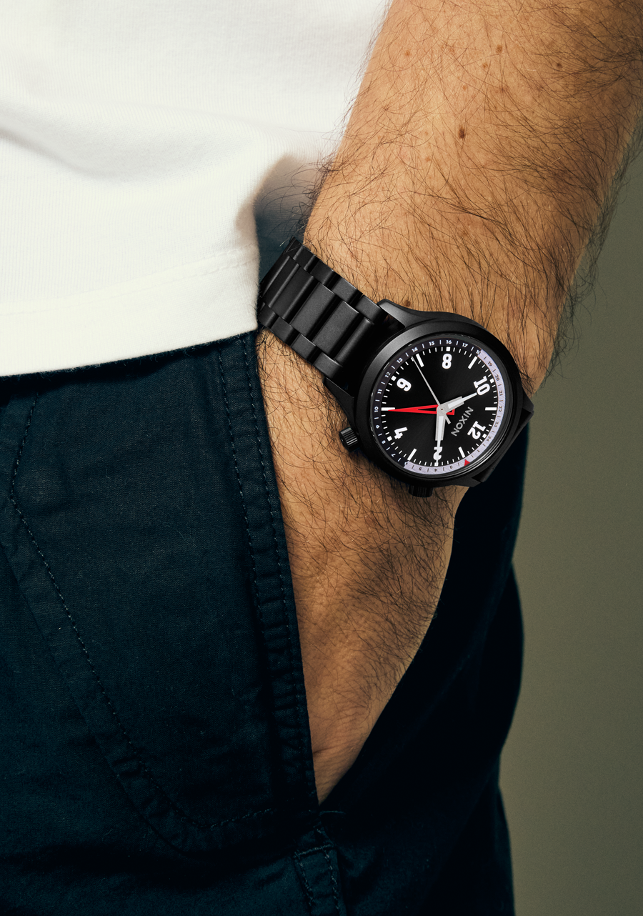 Man wears a Nixon Drifter 40 analog GMT watch